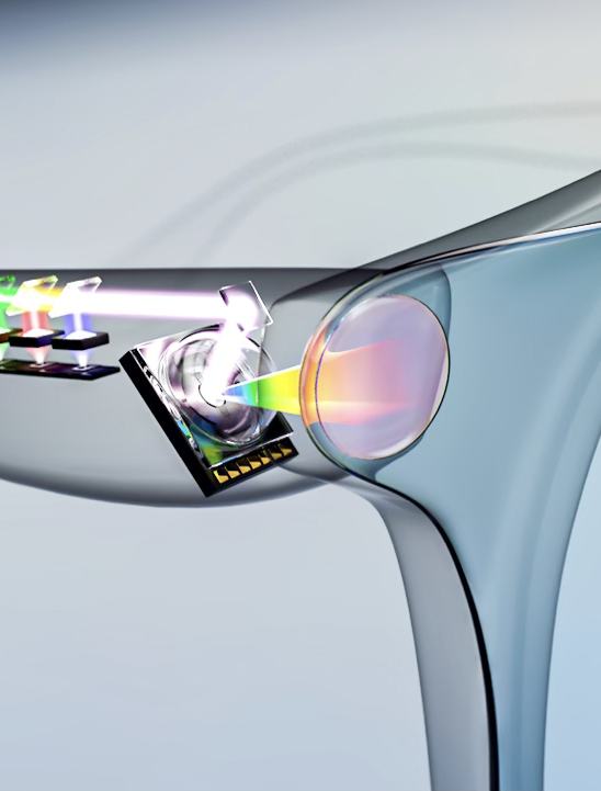A conceptual graphic showing a pair of glasses with a cutaway view of micro-optics and miniature projection components embedded within the frame's arm, casting a multicolored beam through a lens.