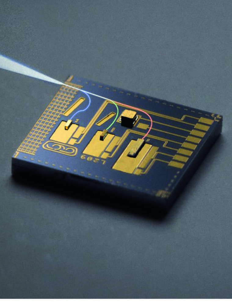 A close-up shot shows a microchip with gold traces and components on a dark background. A pointed instrument enters from the upper left, touching the chip with a thin, glowing fiber that traces lines across the surface.